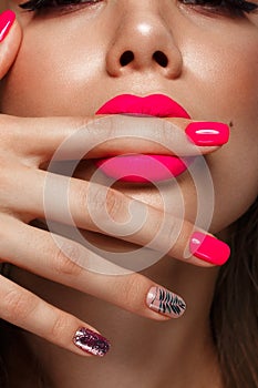 Beautiful young woman with bright makeup and neon pink nails. Beauty face. Photo taken in the studio