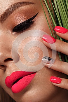 Beautiful young woman with bright makeup and neon pink nails. Beauty face. Photo taken in the studio