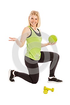 Beautiful young woman in bright sportswear with ball and dumbbells, isolated on white background