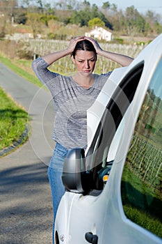 Beautiful young woman with broken down van