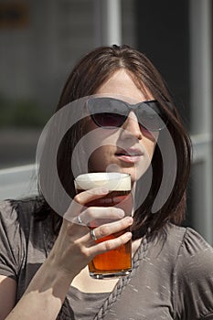 Beautiful Young Woman with Brown Hair Drinking a Pint