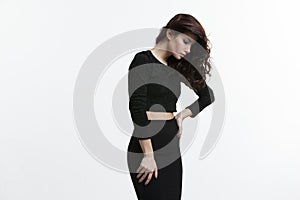 Beautiful young woman with brown long ringlets hairs and make up, wear black clothes, isolated on white background.