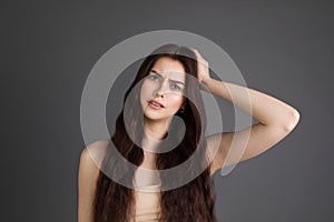 Beautiful young woman with brunette hair suffers from terrible headaches and compresses the head with fingers