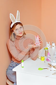 Beautiful young woman with bunny ears making Handmade Easter decoration little rabbit DIY. Reuse concept art from roll.