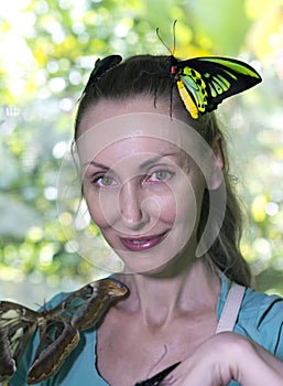 Beautiful young woman in a butterfly park with large tropical butterflies