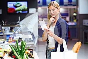 Beautiful young woman buying fresh vegetables and looking shopping list in the market.