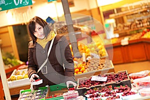 Beautiful young woman buying fruits