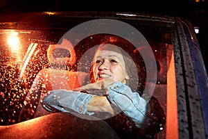 Beautiful young woman in the car at night