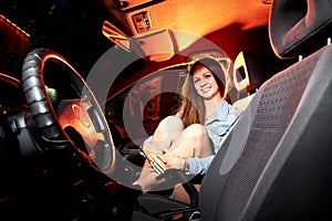 Beautiful young woman in the car at night