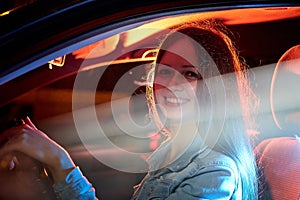 Beautiful young woman in the car at night