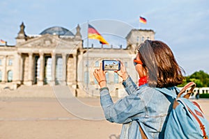 Young woman in casual wear taking photos by her mobile phone at the Bundestag, Berlin