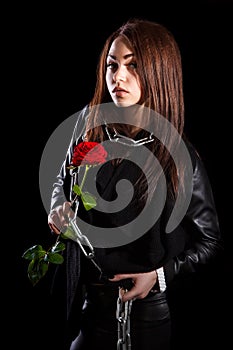 Beautiful young woman with chains and a red rose