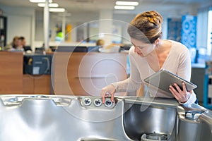 beautiful young woman checking bathtub in shop