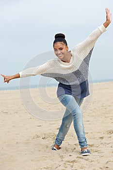 Beautiful young woman with cheerful expression walking on beach