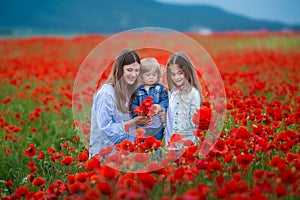 Beautiful young woman with child girl in poppy field. happy family having fun in nature. outdoor portrait in poppies. mother with