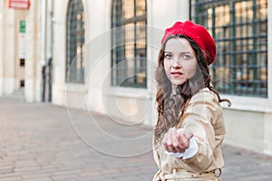 Beautiful young woman at city street. Happy tourist girl walking outdoors. Spring portrait of pretty brunette female posing in old