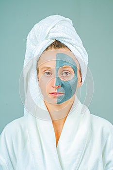 Beautiful young woman with clay facial mask. Skincare and beauty Concept