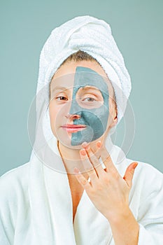 Beautiful young woman with clay facial mask. Skincare and beauty Concept