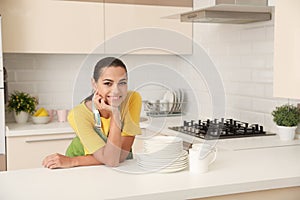 Beautiful young woman with clean dishes and cups