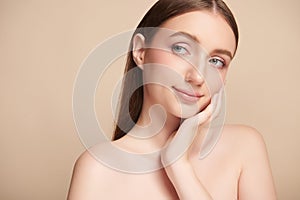 Beautiful young woman with clean fresh skin on beige background, Face care, Facial treatment, Cosmetology, beauty and spa, women