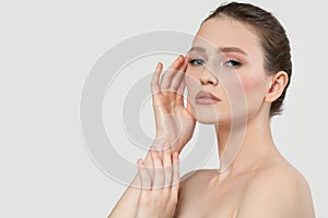 Beautiful young woman with clean fresh skin touching her own face. Facial treatment. Cosmetology, beauty and spa