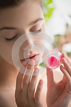 Beautiful young woman with clean perfect skin uses lips sugar scrub