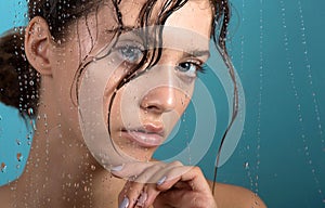 Beautiful young woman with clean perfect skin and water moisture drops touching face