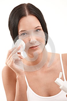 Beautiful young woman cleaning face