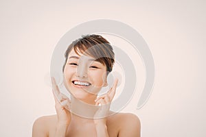 Beautiful young woman cleaning her face with cotton