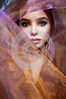 Beautiful young woman in color veil. colorful make-up girl