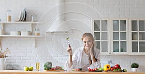 Beautiful young woman cooking healthy food in the loft kitchen at home