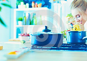 Beautiful young woman cooking in kitchen at home