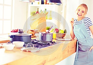 Beautiful young woman cooking in kitchen at home