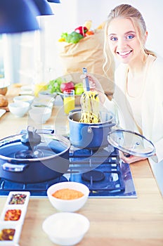 Beautiful young woman cooking in kitchen at home