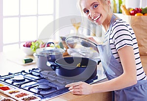 Beautiful young woman cooking in kitchen at home