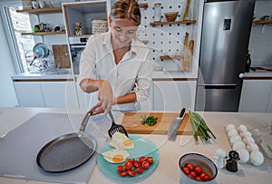 Beautiful young woman cooking in a modern kitchen.