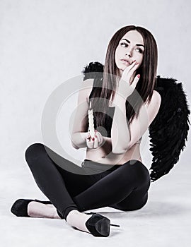 Beautiful young woman in a costume of the dark angel