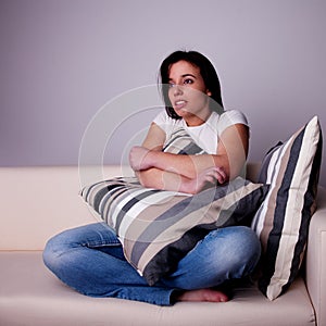 Beautiful young woman, on the couch watching TV,