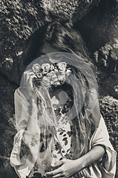 Beautiful young woman cover her face with flowers. black and white portrait. conceptual tilt shift effect