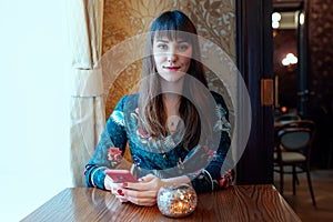 Beautiful young woman with a cup of tea at a cafe