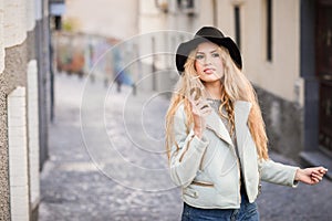 Beautiful young woman with curly hair wearing hat
