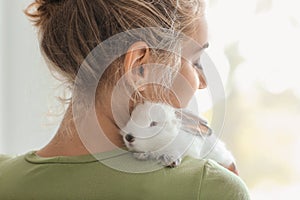 Beautiful young woman with cute rabbit at home