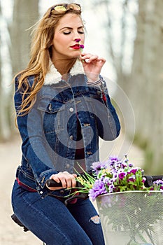 Beautiful young woman cycling in the park.