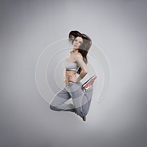 Beautiful young woman dancer jumping in studio