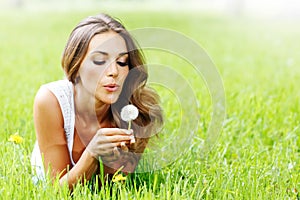 Beautiful young woman with dandelion