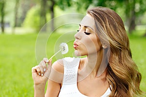 Beautiful young woman with dandelion