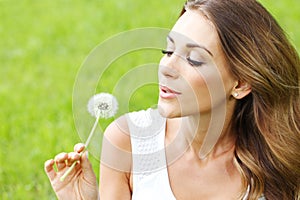 Beautiful young woman with dandelion