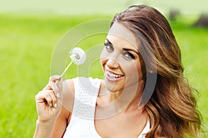 Beautiful young woman with dandelion