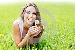 Beautiful young woman with dandelion