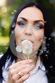 Beautiful young woman with dandelion